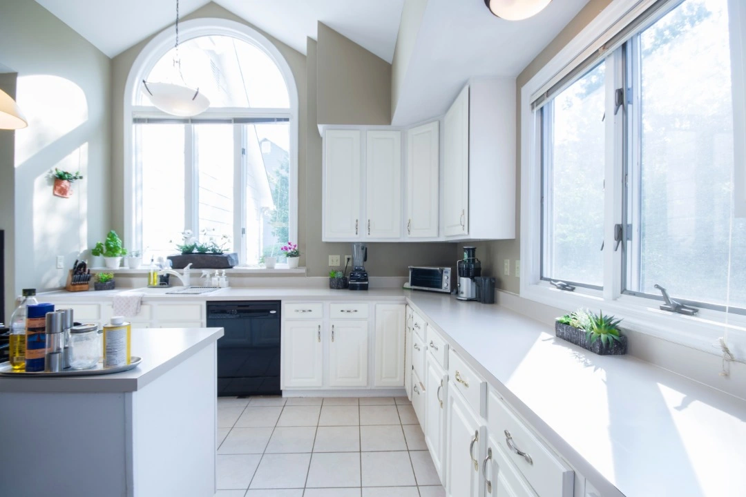 House Kitchen natural lit with white cabinets and island cleaned