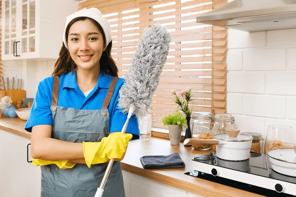 A young brunette maids with gloves and cleaning accessories